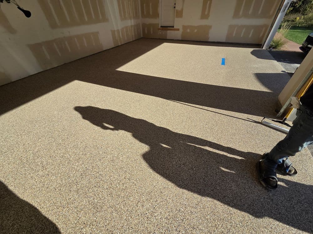 Newly installed epoxy garage floor with shadows and natural light illuminating the surface.